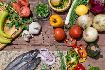 colorful fresh vegetables and fishes on a rustic table. cooking outside.