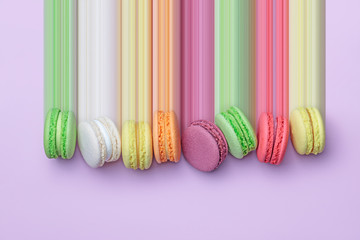 Bovenaanzicht van kleurrijke macaronkoekjes op een rij op pastelkleurige blokachtergrond, plat gelegd, pixeluitrekking