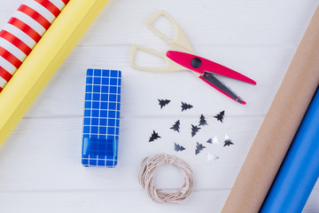 Gift wrapping for Christmas and New Year. Gift box, scissors, string, wrapping paper and Christmas tree cutouts. Preparation for holiday concept.