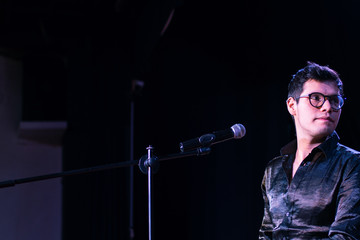 young man singing on stage performing a concert