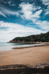 Obraz premium Sunny beach on Magnetic island, Australia with rocks and hills around