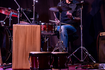 Fototapeta na wymiar Drummer playing live on stage percussion instruments, bongos and peruvian cajon