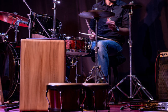 Drummer playing live on stage percussion instruments, bongos and peruvian cajon