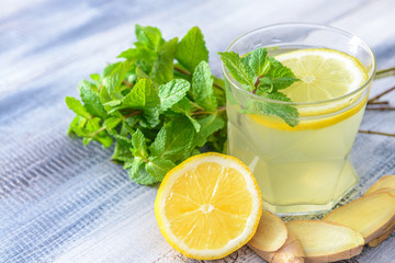 Glass of tasty lemonade on wooden background