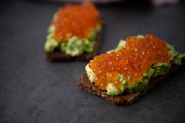 Avocado Toast on Rye Bread Topped with Salmon Ikura