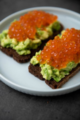 Avocado Toast on Rye Bread Topped with Salmon Ikura