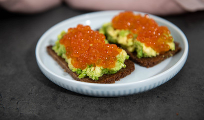 Avocado Toast on Rye Bread Topped with Salmon Ikura