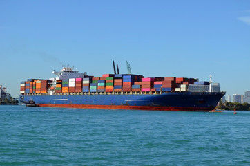 Container ship being aided in cargo unloading pier