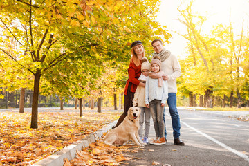 Fototapeta premium Happy family with dog in autumn park