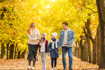 Obraz premium Happy family walking in autumn park