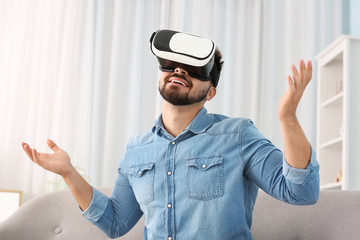 Young man with virtual reality glasses at home