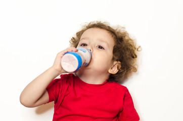 girl drink delicious dairy product from a bottle. child likes healthy yogurt, organic milk to strengthen the body with calcium, vitamin D. healthy nutrition, snack for babies. healthcare concept