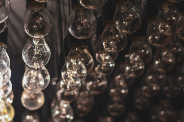 Retro light bulbs background as decoration. Selective focus. Low DOF. Toned image.
