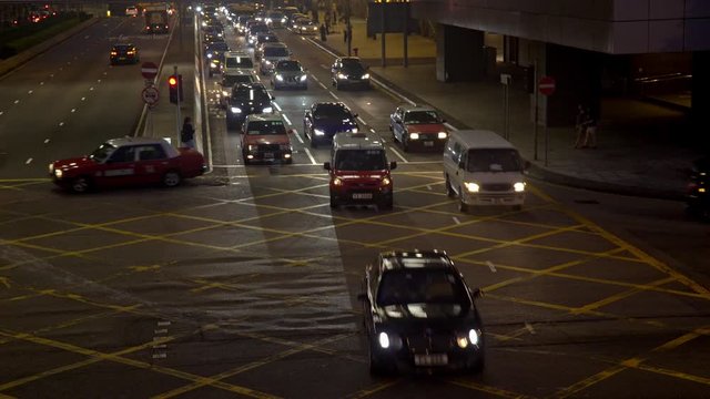 Traffic crossing a busy street on Hongkong island at night