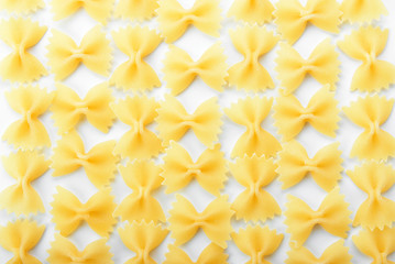 Obraz premium Uncooked farfalle pasta pattern on white background, italian cuisine ingredient, food preparation and cooking