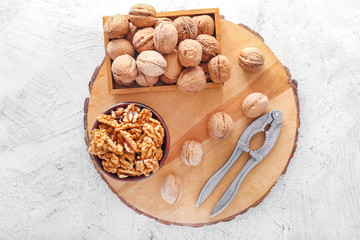 Tasty walnuts with nutcracker on white background