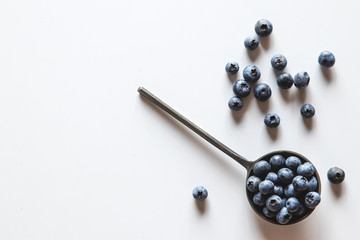 Blueberries in a spoons isolated on a white background. Healthy food, health