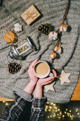 Christmas cup of coffee on a grey background with a blurred lights