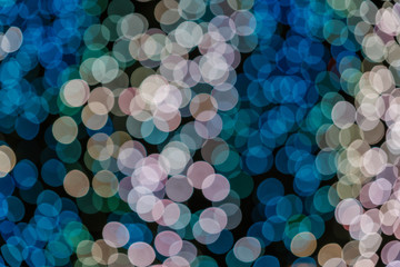 Pink, gold and blue Christmas light shiny abstract round bokeh on black background. Colourful Glitter bokeh from blurry decoration bulbs.