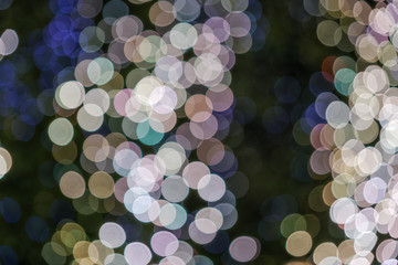 Pink, gold and blue Christmas light shiny abstract round bokeh on black background. Colourful Glitter bokeh from blurry decoration bulbs.