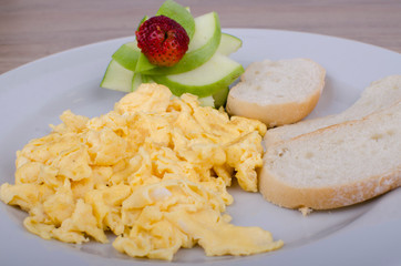 scrambled eggs with bread and fruit