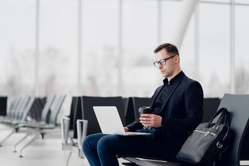 Working on laptop in airport while waiting for flight