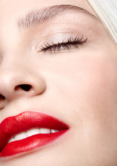 Closeup macro portrait of female face with red smiling lips and beauty makeup.