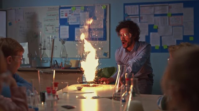 School Chemistry Classroom: Engrossed Children Watch How Enthusiastic Teacher Shows Science Experiment by Setting Powder on Fire Creating Beautiful Fireworks. Kids Getting Fun Modern Education