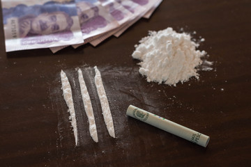 Cocaine drugs heap still life on a table with rolled colombian peso bank note