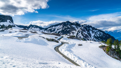 Fototapeta na wymiar Washington, USA. Uphill road landscape in winter at Mount Baker. Asphalt road with sideways full of snow.
