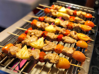 Chicken and pork and various vegetables on barbecue grill cooked