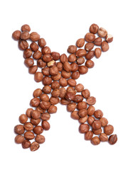 Letter X of the English alphabet from from hazelnut on a white isolated background. Food pattern made from nuts. Bright alphabet for shops.