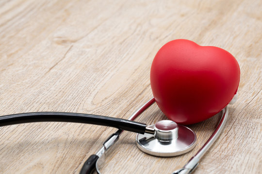 Red heart medical stethoscope and black pen Put on the doctor's charging plate.Health examination concept Health insurance. Medical health. Taking care of yourself as ordered by a doctor.Close up.