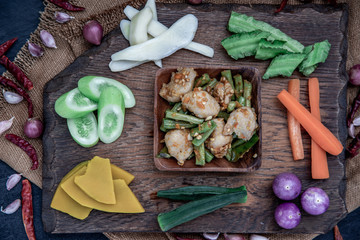 Thai food, Stir Fried fish ball with Red Curry Paste and long bean with the ingredient and fresh vegetables on wood background.