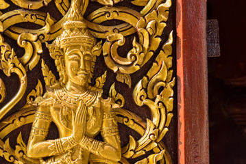 Fototapeta na wymiar Closeup Golden Deva carve on door, Temple in Thailand.