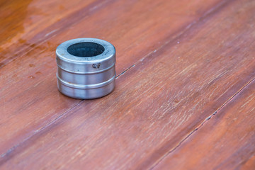 Stainless ashtray against a wooden brown background.
