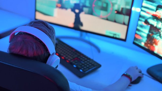 Playing shooter game online on computer at night