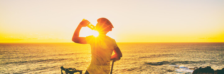 Athlete cyclist man drinking water on bike