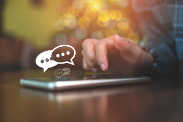 Women hand using smartphone mobile typing, chatting conversation in chat box icons pop up. Social media maketing technology concept.Vintage soft color tone background.