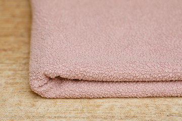 Fototapeta na wymiar Big soft pink folded towel on table