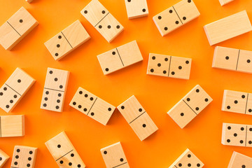 Playing dominoes on a orange table. Leisure games concept. Domino effect.