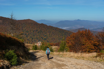 Autumn scenery in the Ukrainian Carpathian Mountains with a tourist girl with a backpack
