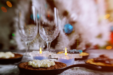 Burning candles on the dinning table, decorated christmas tree for Christmas night.