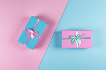 Two pastel gift boxes on a blue-pink background.