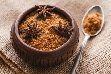 Brown sugar. Close up of wooden bowl with brown sugar and anise
