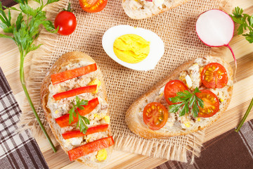 Crispy sandwiches or baguette with mackerel or tuna fish paste on cutting board