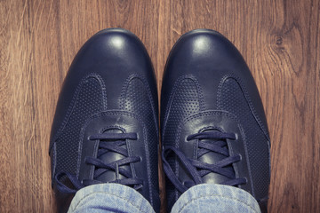 Comfortable navy blue leather shoes on rustic board, male footwear