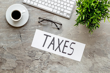 Taxes text on grey office background top view