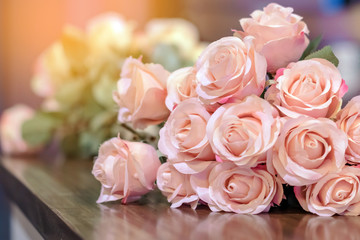 Beautyful bouquet of pink artificial roses placed on the table to decorate the coffee shop.