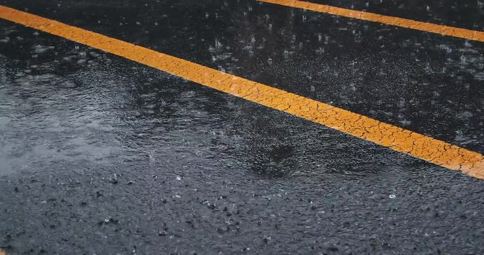 Typhoon in japan. Torrential rain on the asphalt road with yellow warning line.